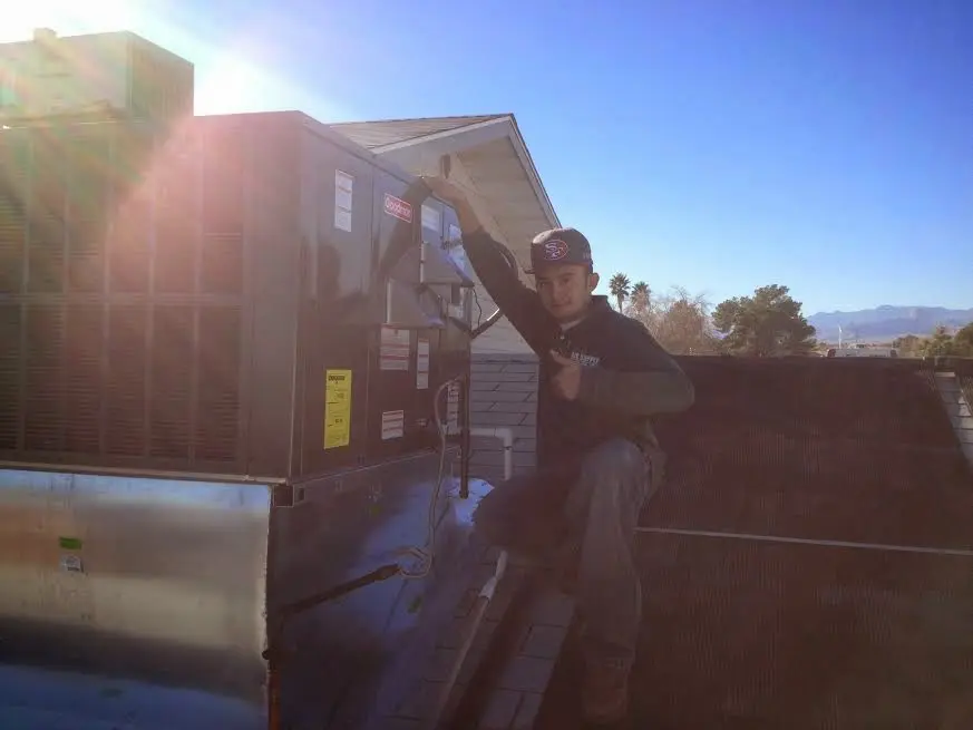 HVAC technician performing Air Duct Repair on a rooftop unit in Primera